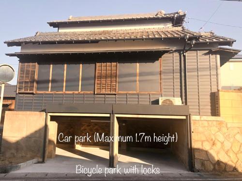 a building with a car park maxume tum tum tum im right at Tomo's INN - priceless experience - in Obu