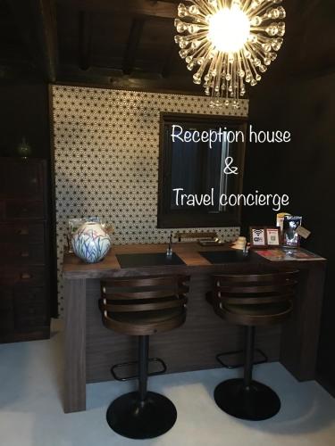 a reception desk with a television and a travel conference sign at Tomo's INN - priceless experience - in Obu