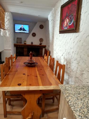 a wooden dining room table with chairs and a television at Cal Massana in Sant Guim de la Plana
