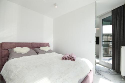 um quarto com uma cama com lençóis brancos e um espelho em Apartamenty HashtagWilda_Apartament Złoty em Poznań