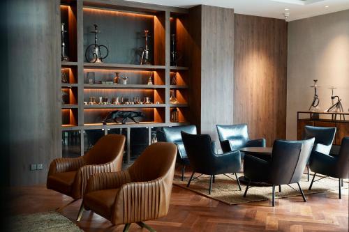 a dining room with chairs and a table and shelves at Opero Hotel Southkey Johor Bahru in Johor Bahru