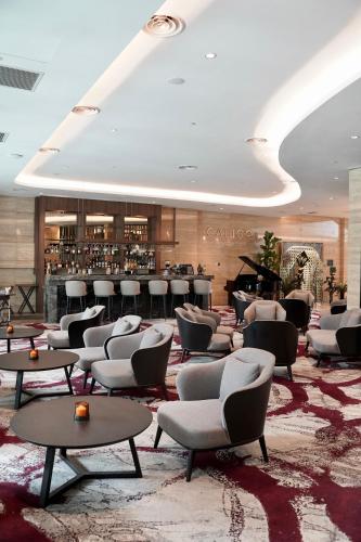 a lobby with chairs and a bar with a piano at Opero Hotel Southkey Johor Bahru in Johor Bahru