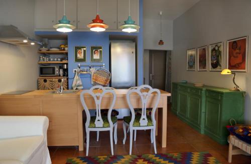 a kitchen with green cabinets and a table with four chairs at Mom’s home in Sitia