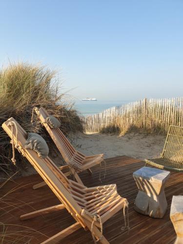 two lounge chairs sitting on a wooden deck at the beach at sangatte " Les Terrasses" maison front de mer Les pieds dans l'eau pleine de charme Cap Blanc Nez Côte d'Opale in Sangatte