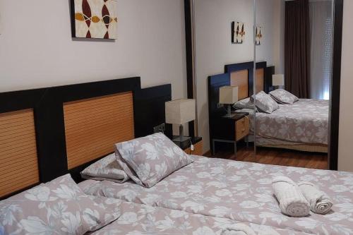 a hotel room with two beds in a room at Elegante alojamiento con piscina a 200 m del mar. in Benalmádena