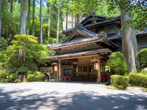an asian style house in a forest with trees at Yunoshimakan in Gero