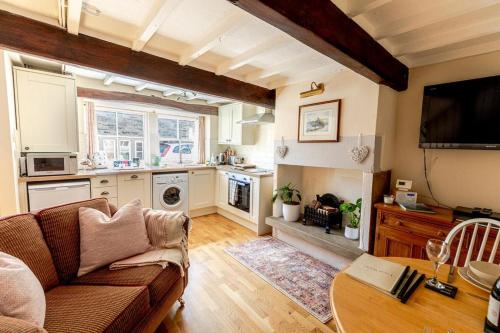 a living room with a couch and a kitchen at FRANCE FOLD COTTAGE - Cosy 1 Bed Cottage Close to Holmfirth & the Peak District, Yorkshire in Honley
