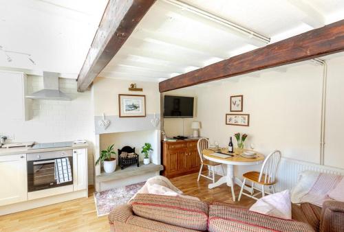 a living room with a couch and a table at FRANCE FOLD COTTAGE - Cosy 1 Bed Cottage Close to Holmfirth & the Peak District, Yorkshire in Honley