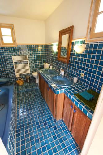 La salle de bains est pourvue de carrelage bleu, d'un lavabo et d'un miroir. dans l'établissement vence, à Vence