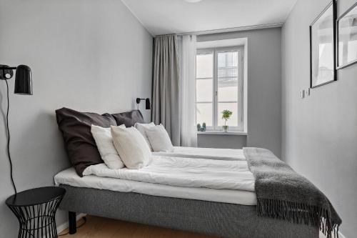 um quarto com uma cama grande e uma janela em Forenom Apartments Stockholm Johannesgatan em Estocolmo
