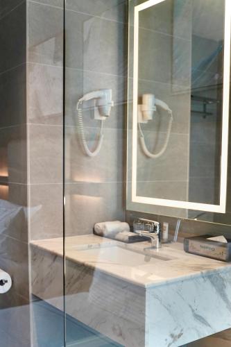 a bathroom with a sink and a mirror at Opero Hotel Southkey Johor Bahru in Johor Bahru