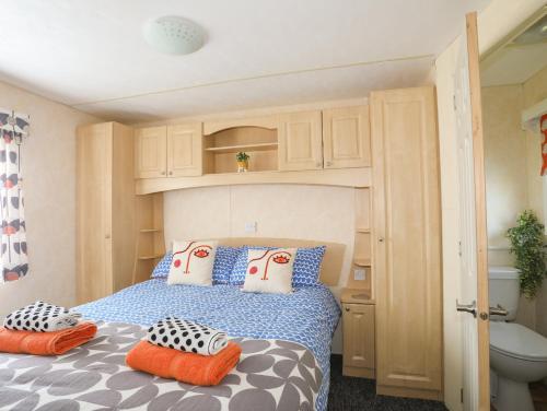 a bedroom with a bed with pillows on it at Trewan Chalet in Holyhead