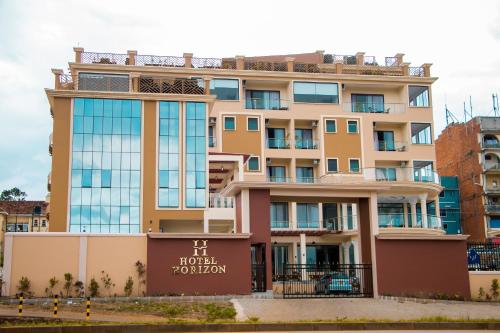 een hotelgebouw met een bord ervoor bij Hotel Horizon Entebbe in Entebbe