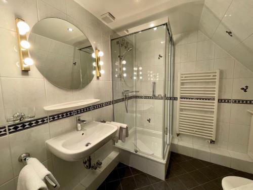 a bathroom with a shower and a sink and a mirror at Landhaus Tons 2 Jan in Keitum