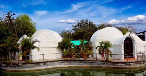 a building with two observatories next to a body of water at Sambodhi Retreat in Bodh Gaya