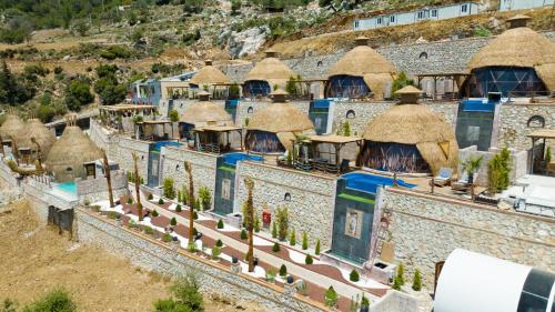 un grupo de edificios con techos de paja en La Lucci Fethiye, en Karaagac