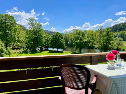 a table with a vase of flowers on a balcony at Gasthof Pension Fischerstüberl in Blaibach