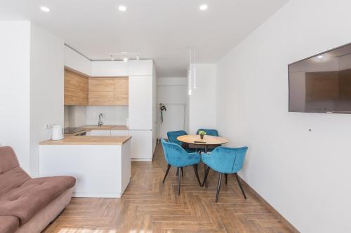 a kitchen and dining room with a table and blue chairs at Простора квартира Віп на вулиці Під Голоском 15 Б in Lviv