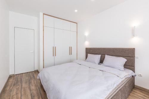a bedroom with a large white bed with white walls at Простора квартира Віп на вулиці Під Голоском 15 Б in Lviv
