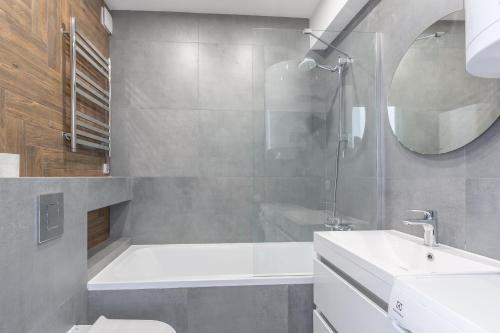 a bathroom with a tub and a sink and a shower at Простора квартира Віп на вулиці Під Голоском 15 in Lviv