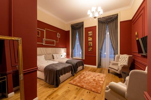 a bedroom with red walls and a bed and a chair at Boutique Hotel Cocosul de Aur in Târgu-Mureş