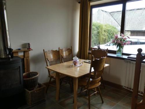 a dining room with a table and chairs and a window at Deveron Valley Cottages in Marnoch