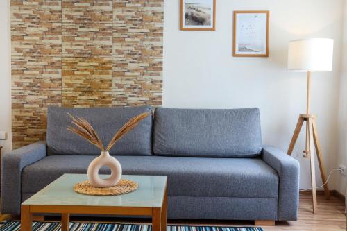 uma sala de estar com um sofá azul e uma mesa em Laguna Self Check-in em Nida