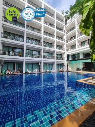 a hotel swimming pool in front of a building at Paripas Patong Resort in Patong Beach