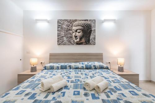 a bedroom with a king sized bed with a painting on the wall at Casa vacanza Porto Luna Villasimius in Villasimius