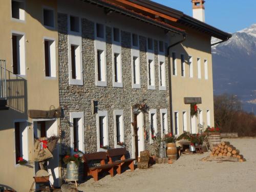 a building with a bunch of chairs in front of it at Agriturismo La Casa Nei Boschi in Colderù