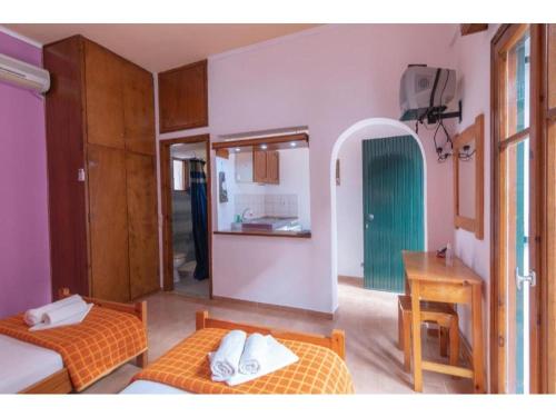 Zimmer mit 2 Betten und einem Tisch in der Unterkunft Steki Studio 2 in Benitses