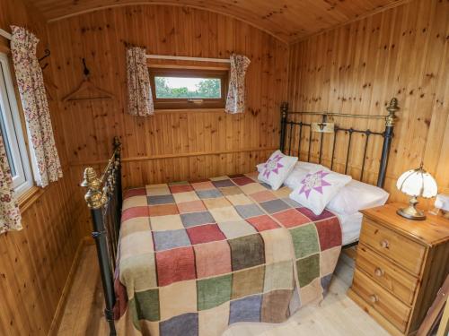 um quarto com uma cama num chalé de madeira em Shepherds Retreat em Kidderminster