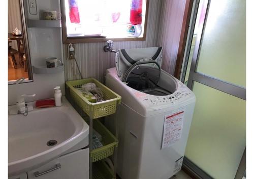 y baño con lavabo y lavadora. en Guest House Inujima / Vacation STAY 3516 en Toyama