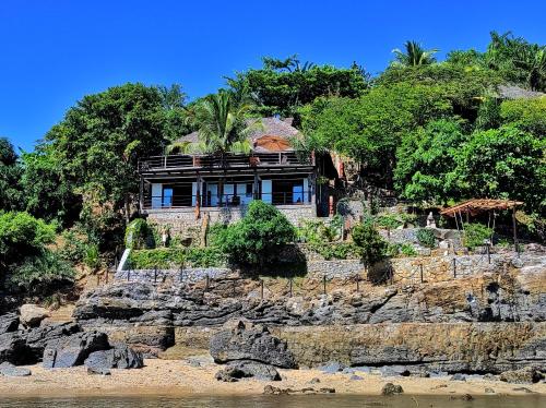 a house on top of a rocky cliff at Villa Nautilus in Nosy Komba
