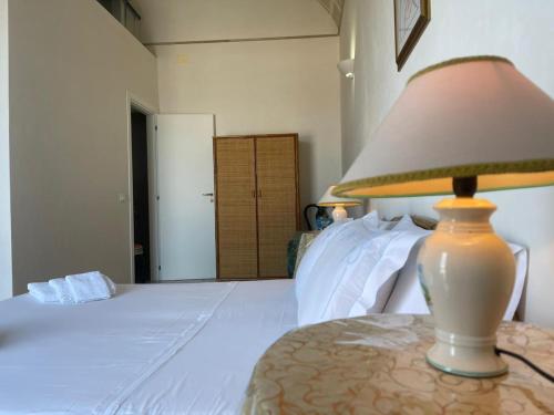 een lamp op een tafel naast een bed bij La camera sul porto in Marettimo