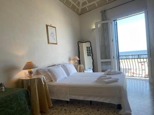 een slaapkamer met een bed en een groot raam bij La camera sul porto in Marettimo