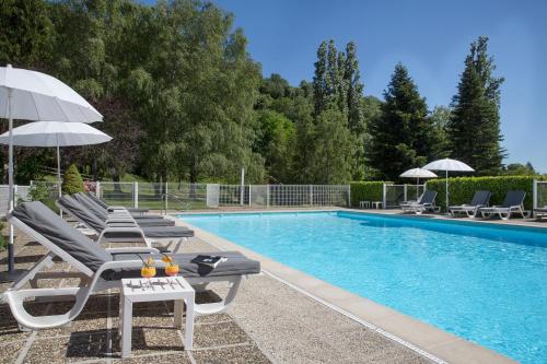 une piscine avec des chaises et des parasols à côté dans l'établissement Les Lodges du Revermont, à Passenans