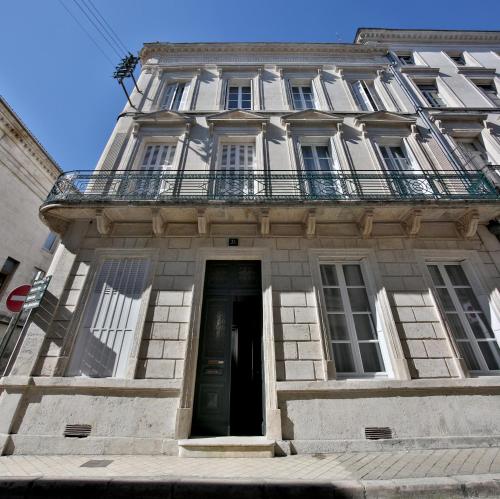 un bâtiment avec un balcon au-dessus dans l'établissement Meublés de l'Arsenal cœur de ville !, à Angoulême