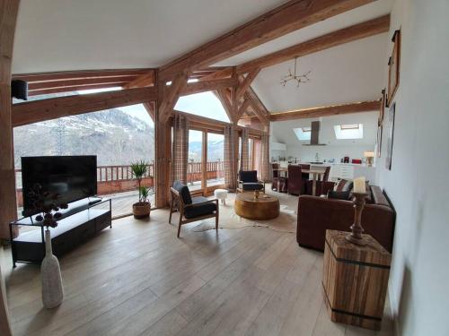 a living room filled with furniture and a large window at Chalet entier 110m2 avec vue et sauna à 10 min des pistes in Sainte-Foy-Tarentaise