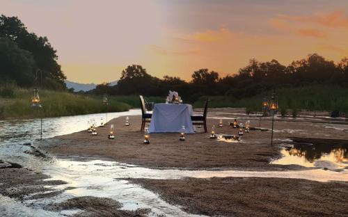 a table and chairs on a beach with a table and lights at Karongwe - Kuname Safari Lodge in Hoedspruit