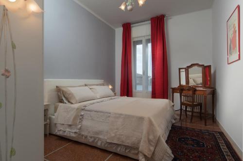 ボローニャにあるB＆B アル パルコ ジャルディニ マルゲリータのベッドルーム1室(赤いカーテンと鏡付きのベッド1台付)
