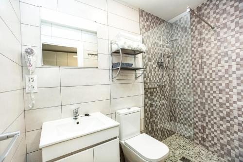 a white bathroom with a toilet and a sink at LIA in Muxia