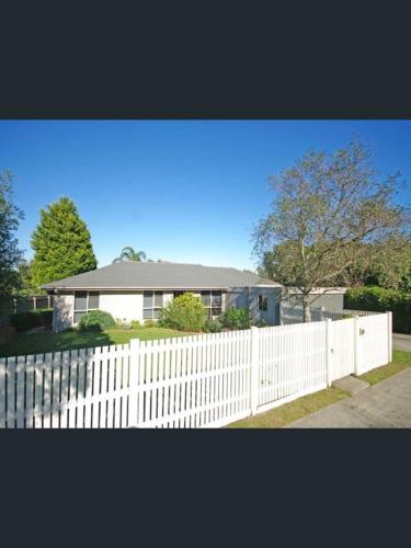 a white fence in front of a house at ravenhill house in Eumemmerring