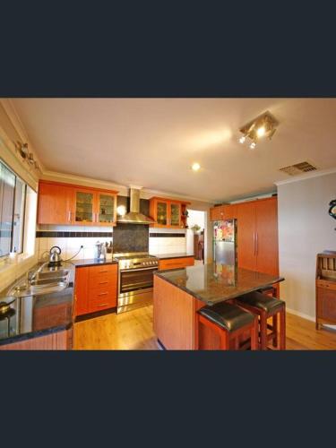 a kitchen with wooden cabinets and a counter top at ravenhill house in Eumemmerring