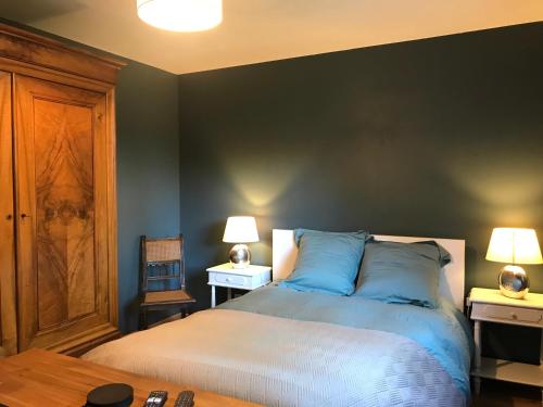 a bedroom with a bed with blue sheets and two lamps at Gite des 2 chênes entre Avenue verte, Lacs, Piscine et Casino in Forges-les-Eaux