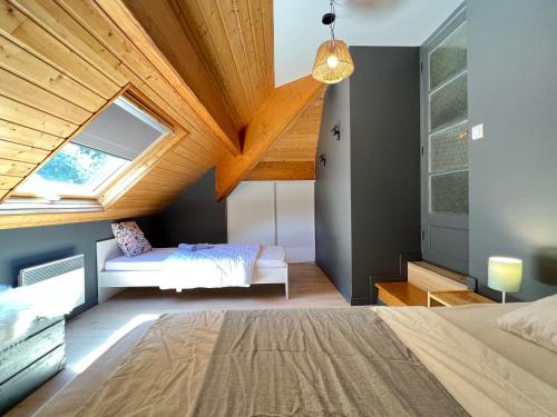 a attic bedroom with a bed and a window at Sur les hauteurs de Cauterets, 2 chambres 5 pers in Cauterets