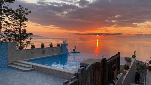 a swimming pool with a sunset in the background at Resort - Località Santa Barbara in Bagnara Calabra