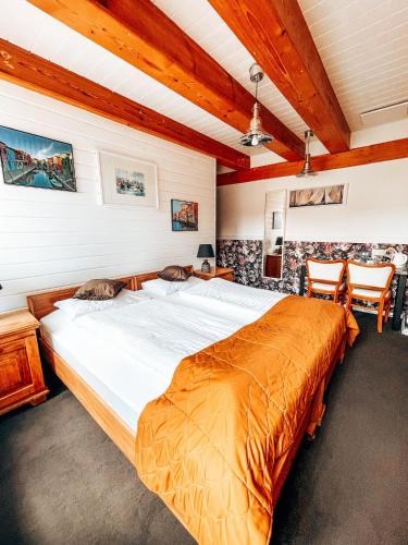 a large bed in a room with wooden ceilings at Villa Bella Italia in Mikołajki
