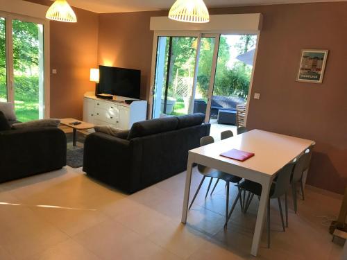 un salon avec un canapé et une table dans l'établissement Gite des 2 chênes entre Avenue verte, Lacs, Piscine et Casino, à Forges-les-Eaux