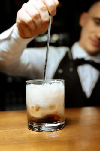 a person is stirring a drink with a spoon at Medeu in Kostanay